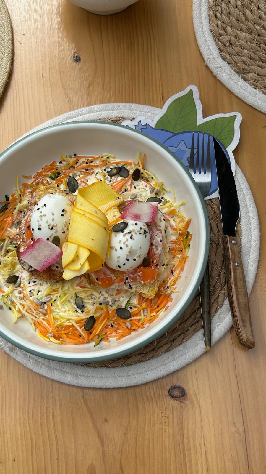 Assiette de cuisine holistique avec œufs, légumes de saison et graines, préparée chez Origines be holistic.