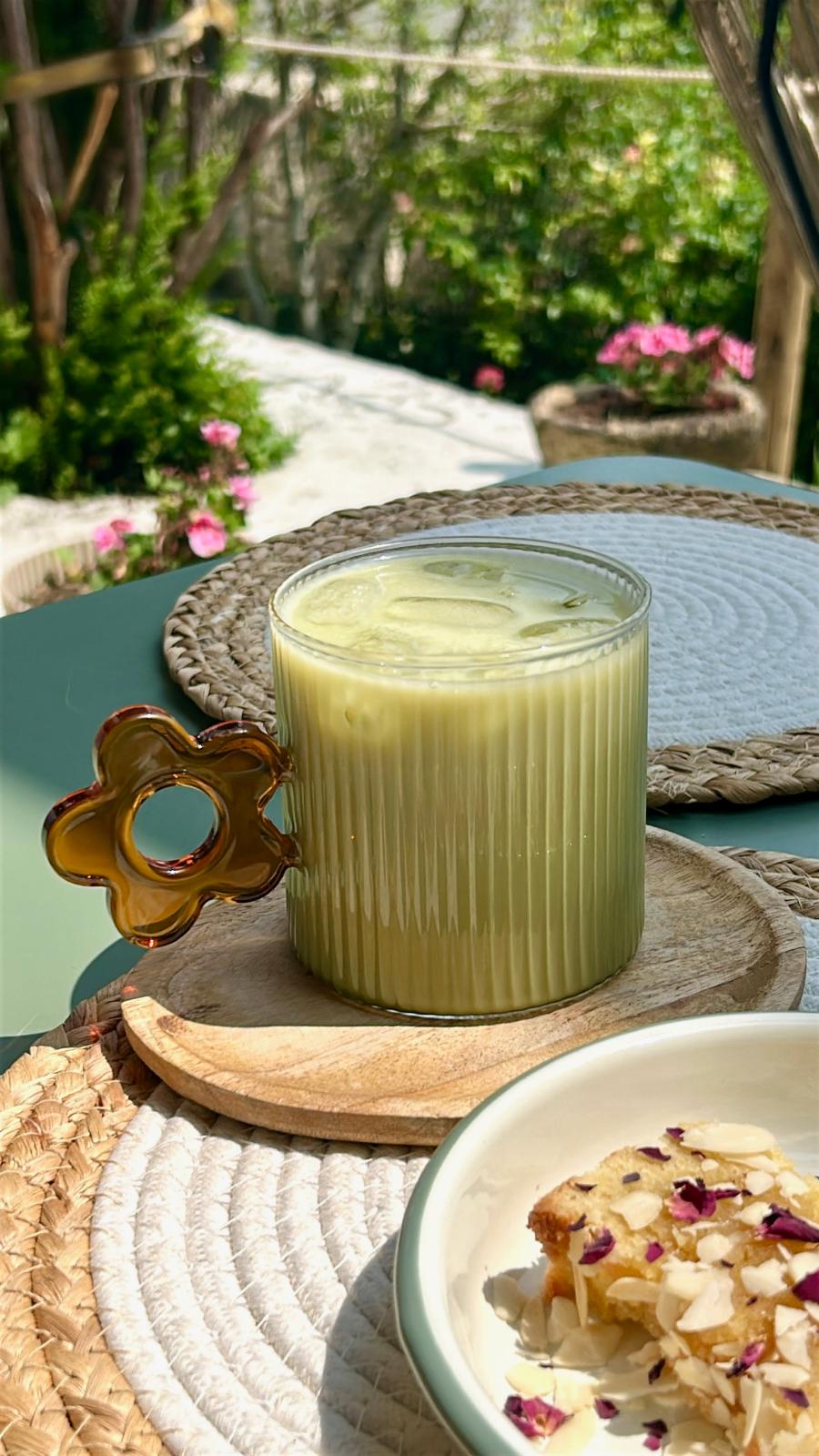 Boisson holistique à base de lait végétal, servie en extérieur lors d’un moment calme chez Origines be holistic.