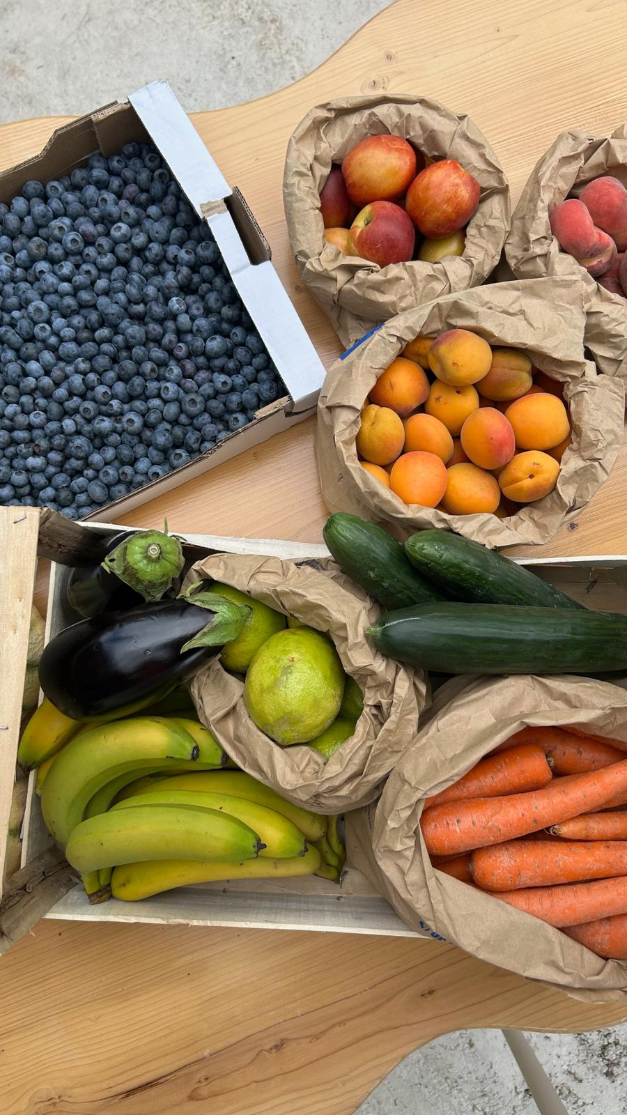 Fruits et légumes frais de saison disposés sur une table, utilisés dans la cuisine d’Origines be holistic.